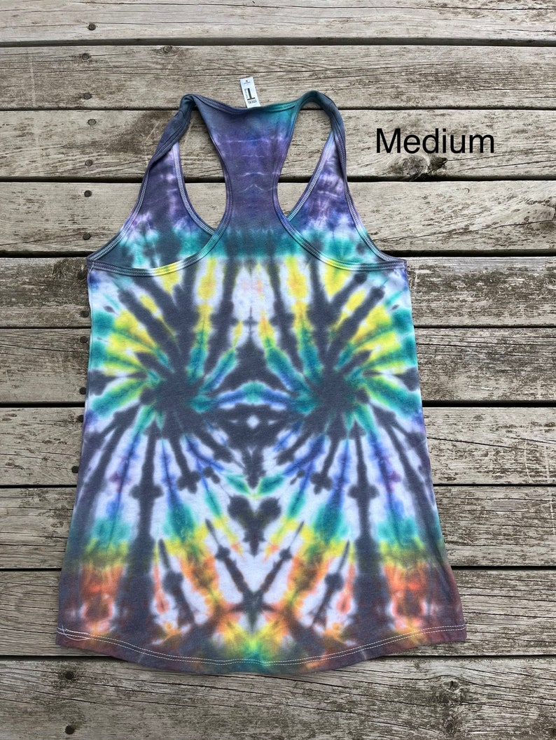 K&ouml;nnte beinhalten: Ein Batik-Tanktop mit einem schwarzen, blauen, gr&uuml;nen, gelben und orangefarbenen Wirbelmuster. Das Tanktop ist mit "Medium" gekennzeichnet.