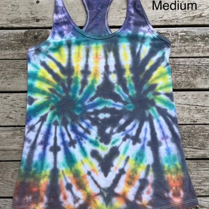 K&ouml;nnte beinhalten: Ein Batik-Tanktop in den Farben Grau, Blau, Gr&uuml;n, Gelb und Orange. Das Tanktop hat einen Racerback-Stil und ist mit "Medium" gekennzeichnet.