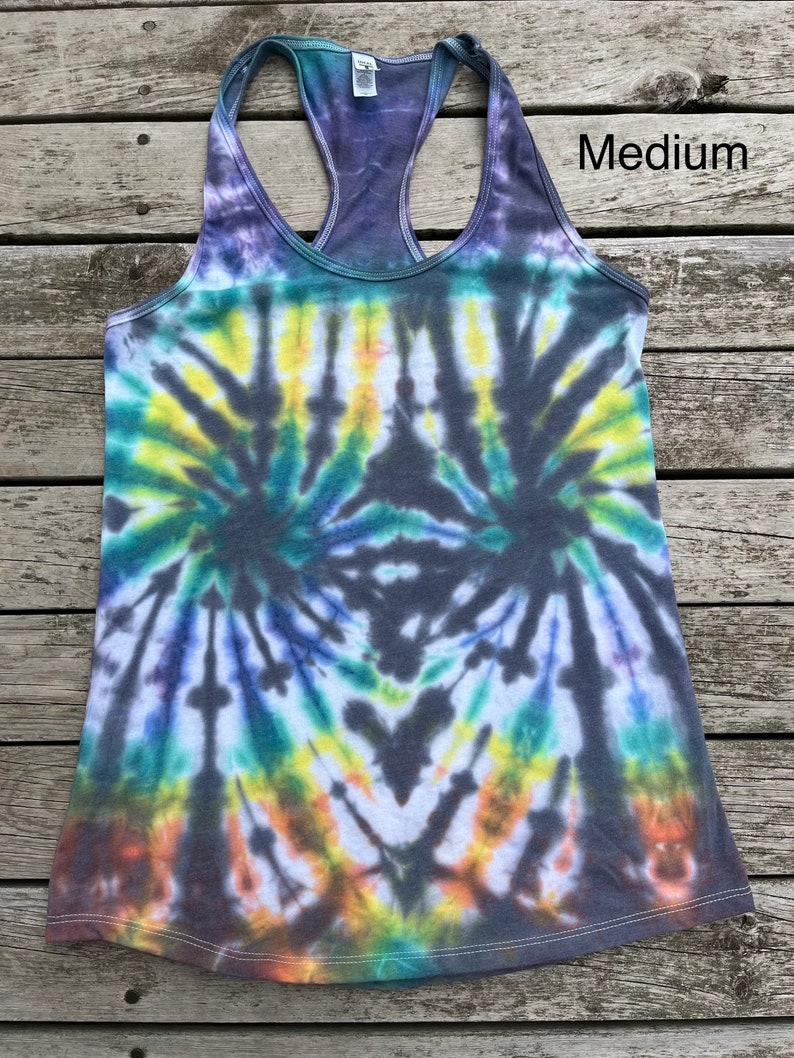 K&ouml;nnte beinhalten: Ein Batik-Tanktop in den Farben Grau, Blau, Gr&uuml;n, Gelb und Orange. Das Tanktop hat einen Racerback-Stil und ist mit "Medium" gekennzeichnet.