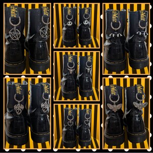 May include: Black leather boots with decorative charms. Charms include a pentagram, a bat, a dragon, a skull, a heart, and a moth. The boots have a glossy finish and yellow stitching. Charms are attached to the back of the boots.