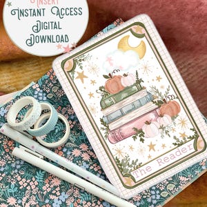 May include: A digital download for a Kindle case insert featuring a stack of books with pumpkins, a crescent moon, and stars on a white background. The text "The Reader" is at the bottom of the design.