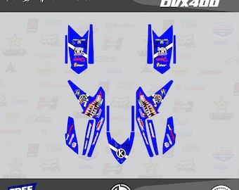 May include: Blue and white graphic decals for an Arctic Cat DUX400, featuring the text "PREDATOR SERIES." The decals include various logos and designs, including a shark mouth graphic. The image also includes the text "KALAIR GFX" and "MADE IN USA."