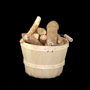 May include: A wooden basket filled with brown and white horseradish roots.