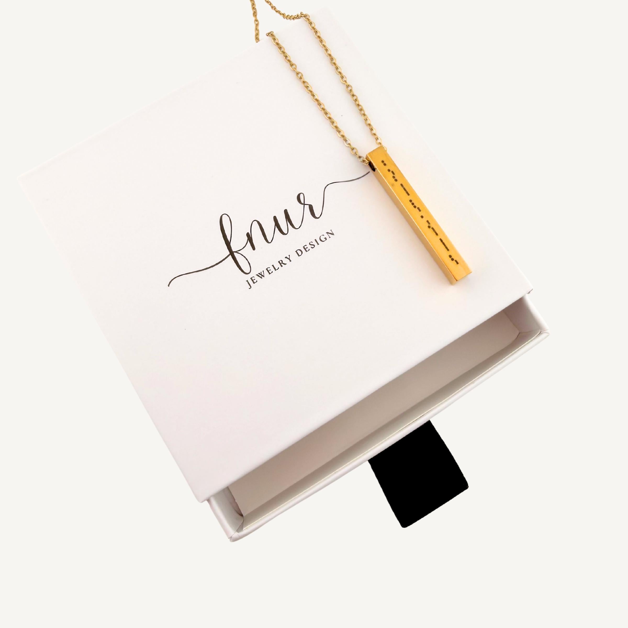 perspective shot of dainty bar necklace showcasing professional metal engraving