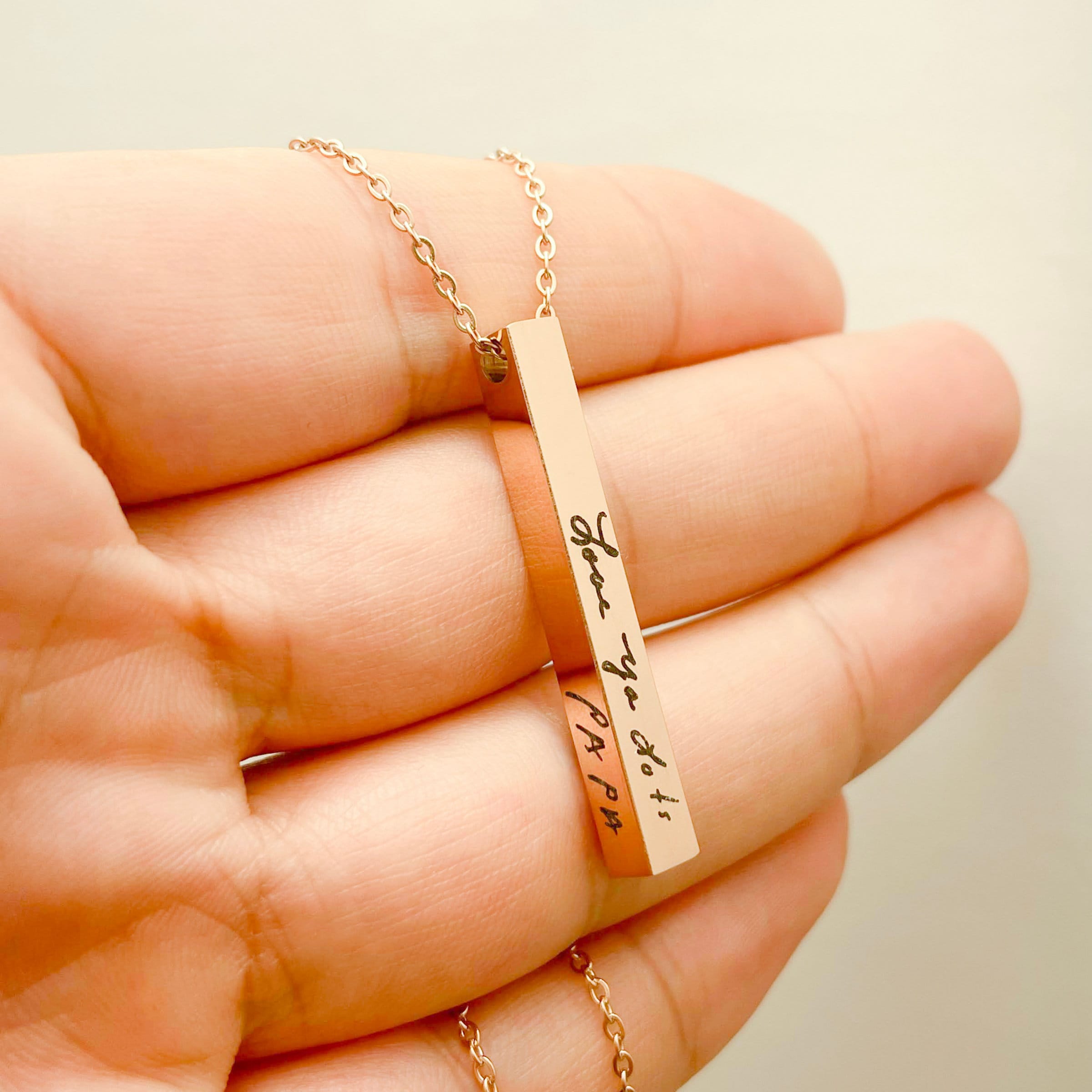 lifestyle shot of woman wearing gold signature bar necklace with casual everyday outfit
