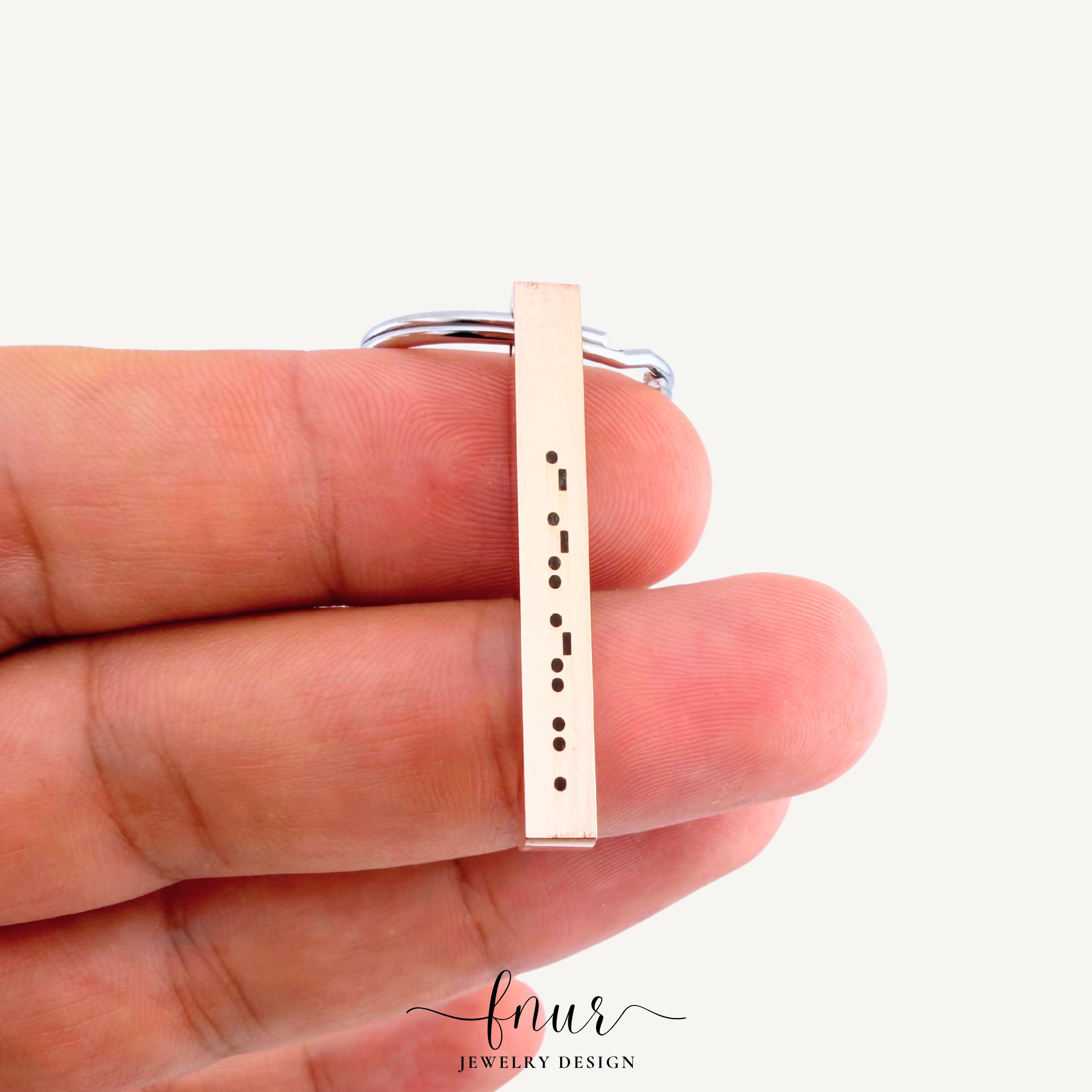 model holding personalized morse code bar keychain demonstrating ideal size and durable hanging weight