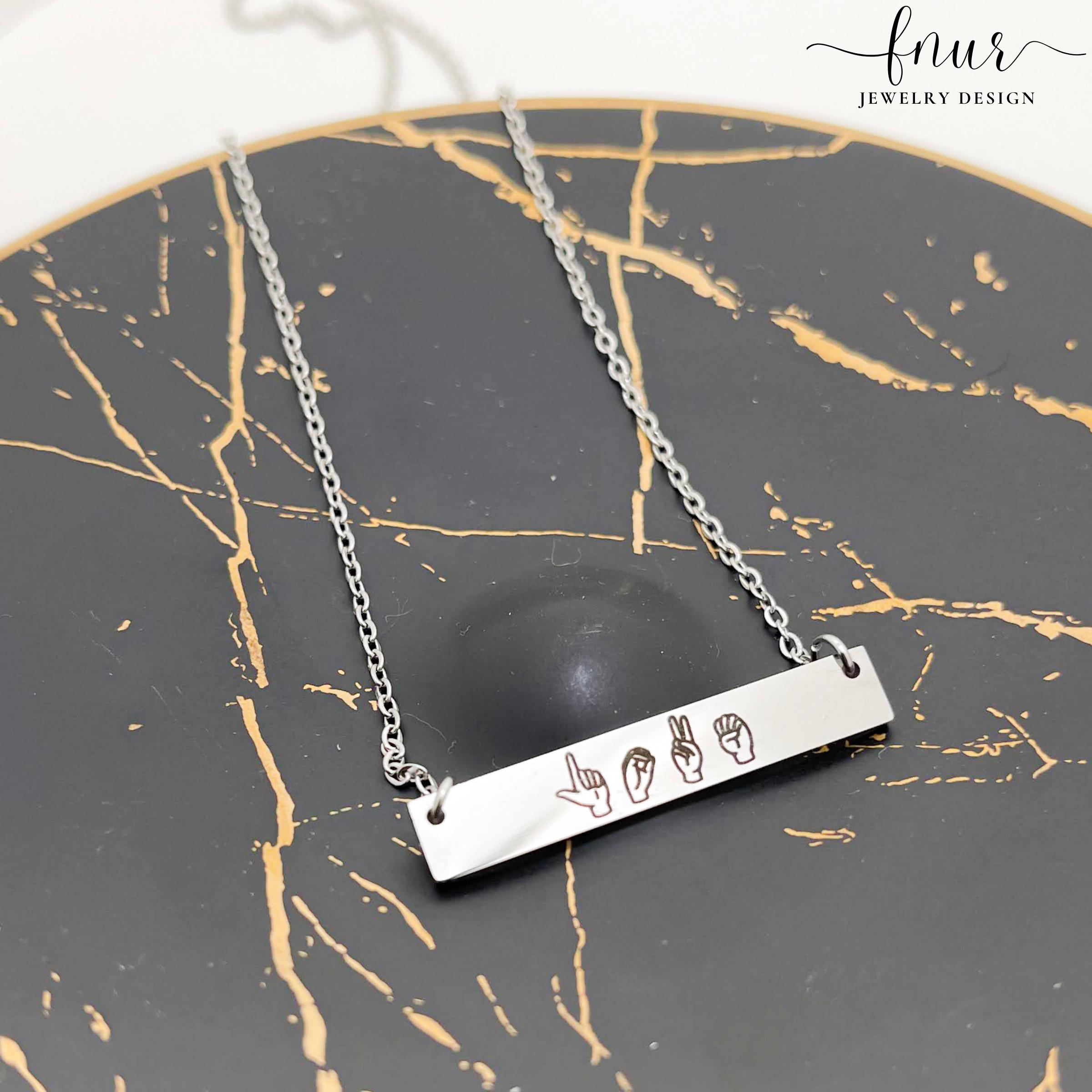 model wearing minimalist black asl bar necklace against neutral backdrop for scale
