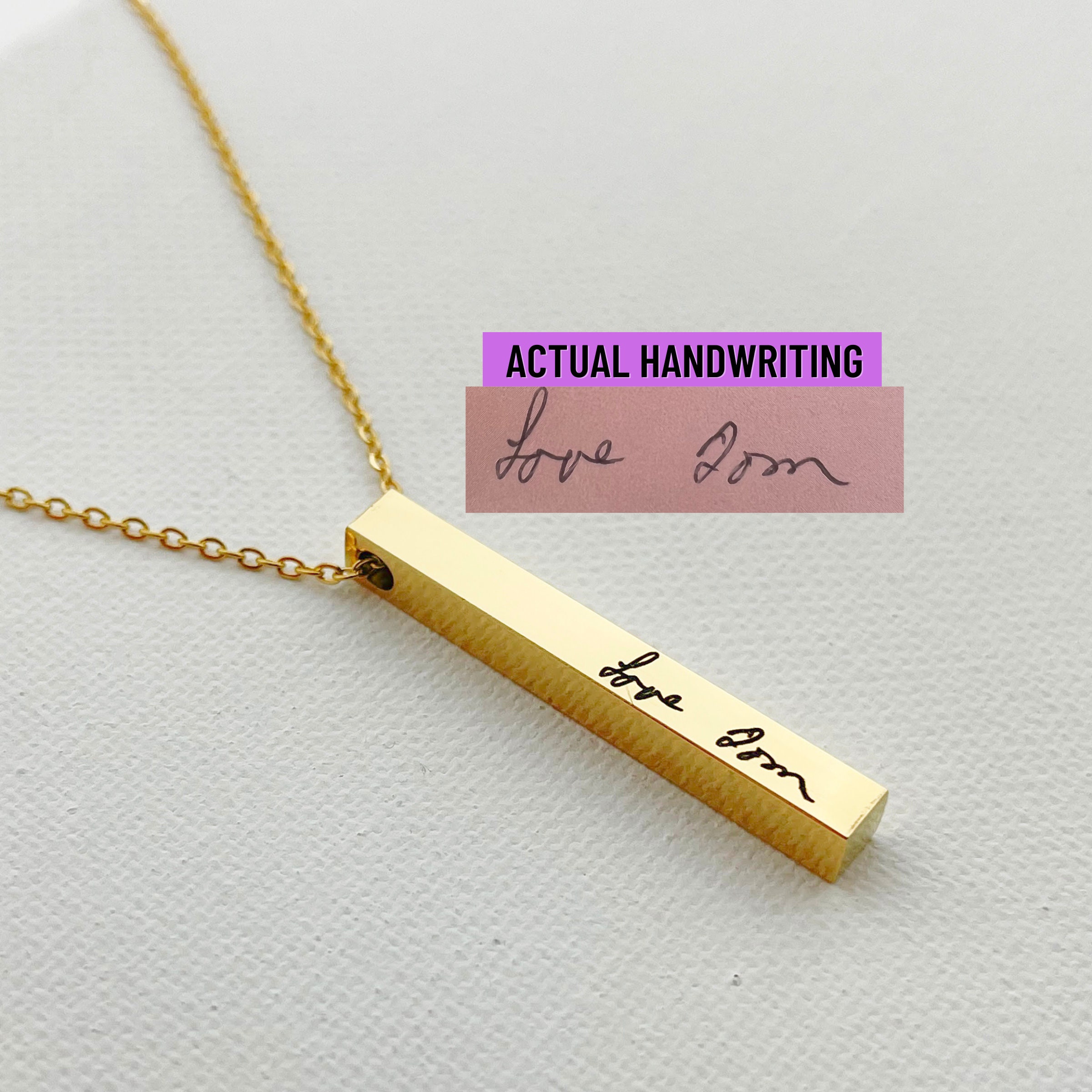 four sided bar necklace featuring multiple personalized engravings held in artisan studio setting