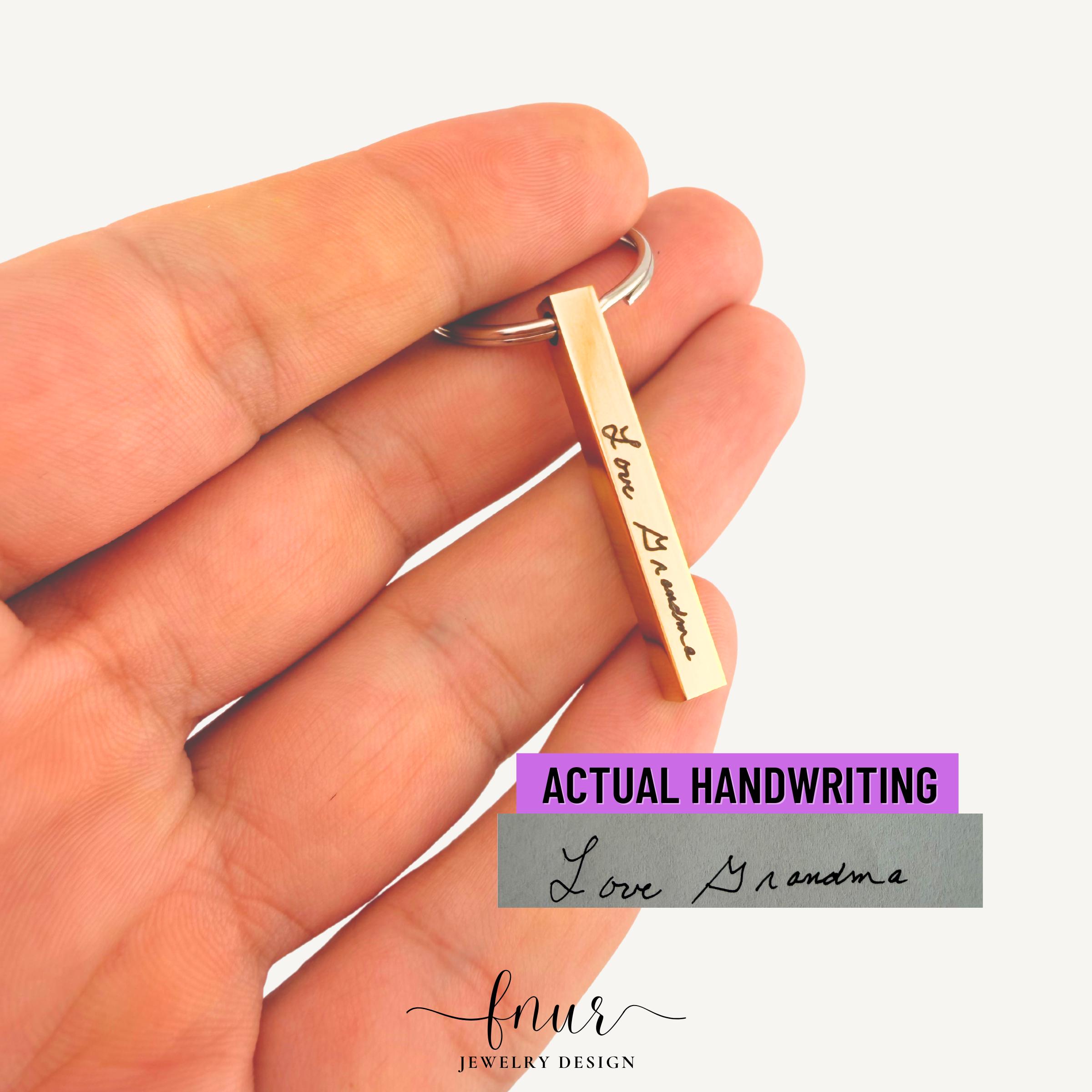 Detail view of handwriting keychain bar featuring child drawing engraving for sentimental memorial gift idea