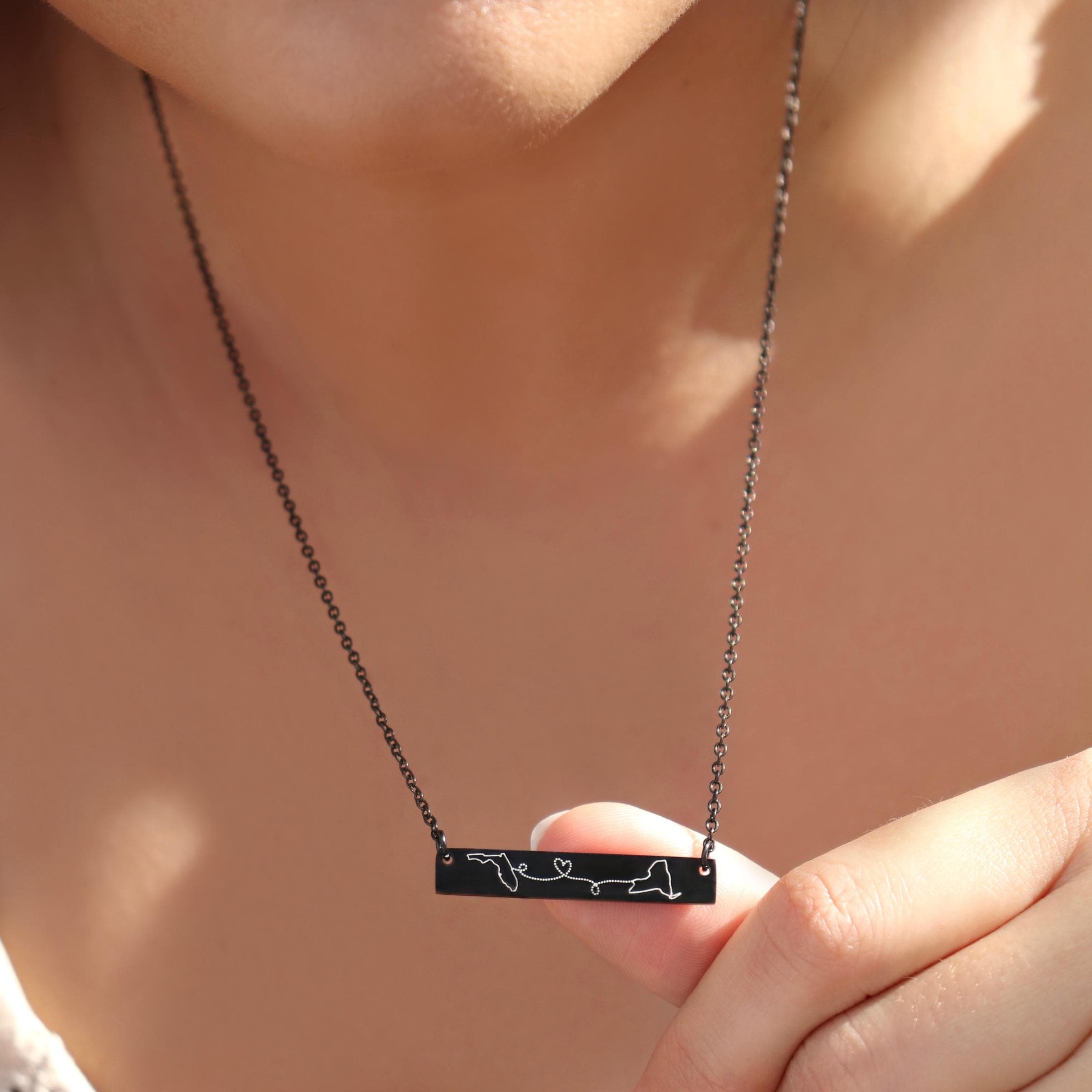 model wearing rose gold distance necklace featuring two country pendants on 20 inch chain