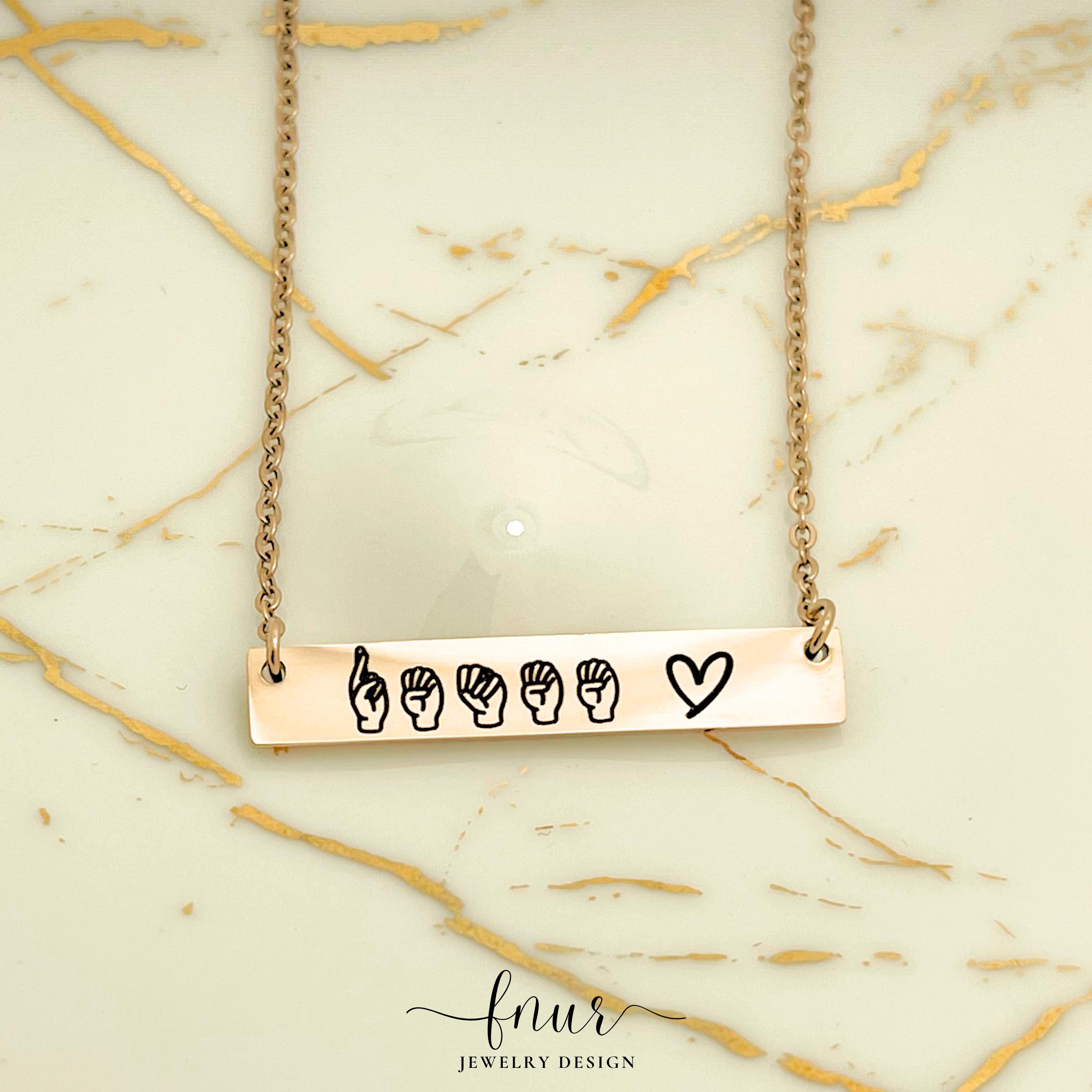 rose gold sign language necklace displayed on professional velvet jewelry display stand