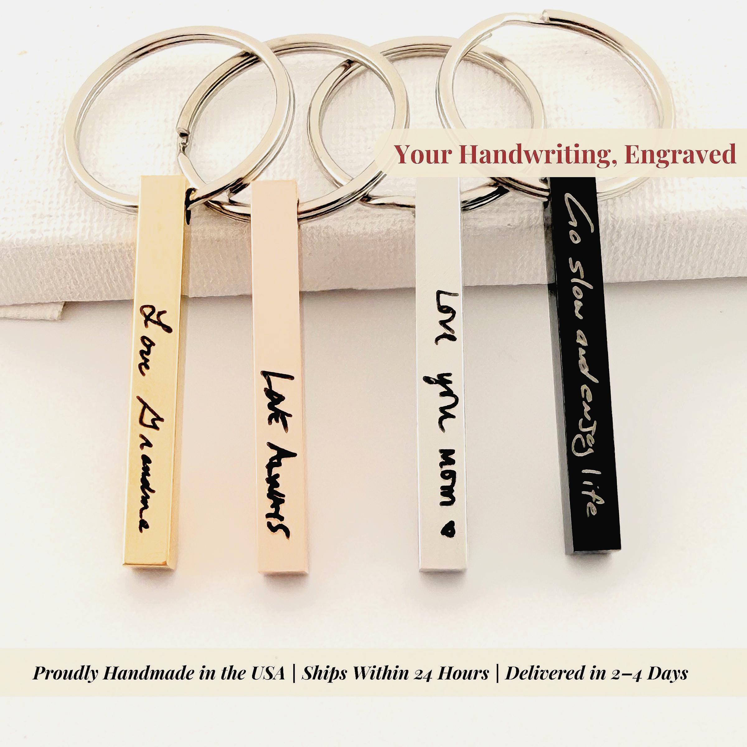 Close up macro shot of authentic signature engraving on elegant bar keychain for personalized gifting