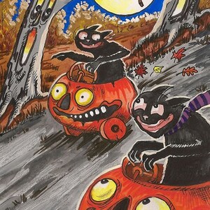 Könnte beinhalten: Zwei schwarze Katzen fahren nachts mit Kürbisautos auf einer Straße. Die Katzen tragen Schals und haben ein breites Lächeln. Ein Vollmond leuchtet hell am Himmel.