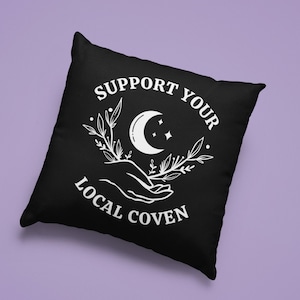 May include: Black throw pillow with white text that reads "Support Your Local Coven" and a crescent moon with stars and floral design.