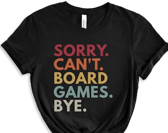 May include: Black t-shirt with the text "SORRY. CAN'T. BOARD GAMES. BYE." in a retro rainbow color scheme.