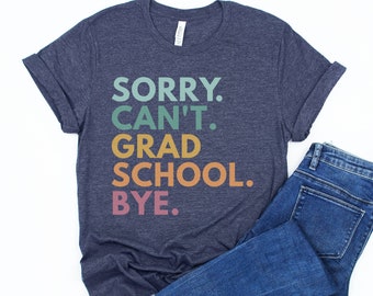 May include: A navy blue t-shirt with the text "SORRY. CAN'T. GRAD SCHOOL. BYE." in rainbow colors.