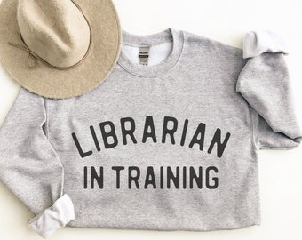 May include: A gray sweatshirt with the text "LIBRARIAN IN TRAINING" printed in black.
