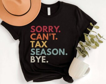 May include: Black t-shirt with the text "SORRY. CAN'T. TAX SEASON. BYE." in a retro rainbow color scheme.