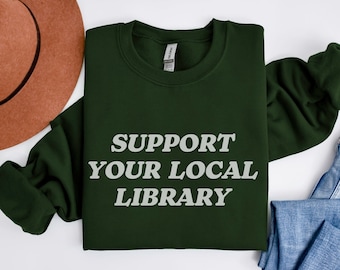 May include: A dark green sweatshirt with the text "Support Your Local Library" in white lettering.