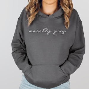 May include: A charcoal gray hoodie with a white cursive inscription that reads "morally grey".