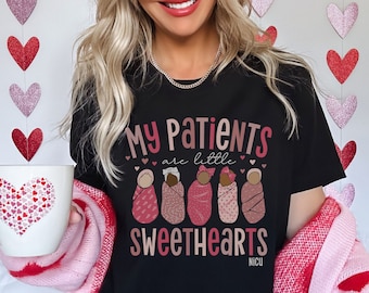 Puede incluir: Camiseta negra con el texto "Mis pacientes son pequeños amores NICU" y un gráfico de cinco bebés envueltos en mantas.