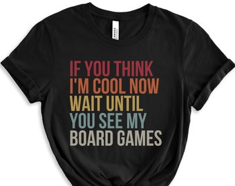 May include: Black t-shirt with a vintage-style graphic that reads "If you think I'm cool now wait until you see my board games".