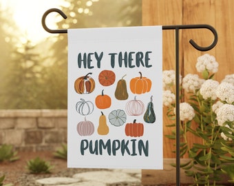 May include: A white garden flag with the text "Hey there pumpkin" in black and a pattern of various pumpkins and gourds in orange, brown, green, and white.