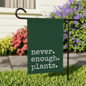 May include: A green garden flag with white text that reads "never. enough. plants."