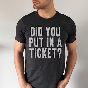 May include: A dark grey t-shirt with the text "Did you put in a ticket?" printed in white.