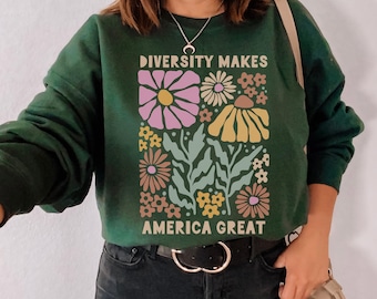 May include: A dark green sweatshirt with a floral design and the text "Diversity Makes America Great".