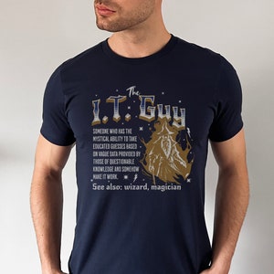 May include: A navy blue t-shirt featuring a graphic of a wizard and the text "The I.T. Guy" with a description of the I.T. Guy as someone who has the mystical ability to take educated guesses based on vague data provided by those of questionable knowledge and somehow make it work. The text also says "See also: wizard, magician".