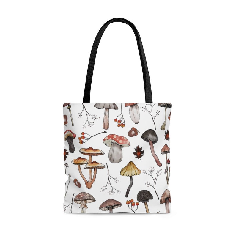 May include: White tote bag with a repeating pattern of watercolor mushrooms and berries. The mushrooms are in various shades of brown, red, and white.