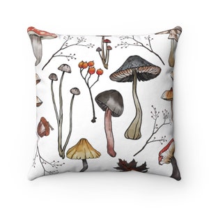 K&ouml;nnte beinhalten: Ein wei&szlig;es Kissen mit einem bunten Pilzmuster. Die Pilze sind im Aquarell-Stil gezeichnet und haben verschiedene Farben, darunter Rot, Orange, Braun und Grau. Das Kissen ist perfekt, um jedem Raum einen Hauch von Natur zu verleihen.