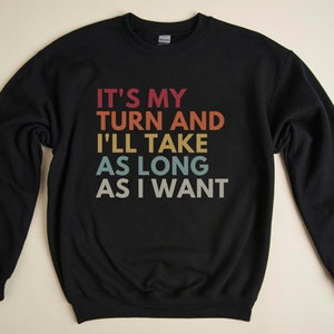 May include: Black sweatshirt with the text "It's my turn and I'll take as long as I want" in a rainbow color scheme.