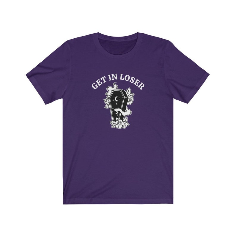 May include: Purple short-sleeved t-shirt with the text "GET IN LOSER" in white above a black and white illustration of a coffin with a crescent moon and flowers.