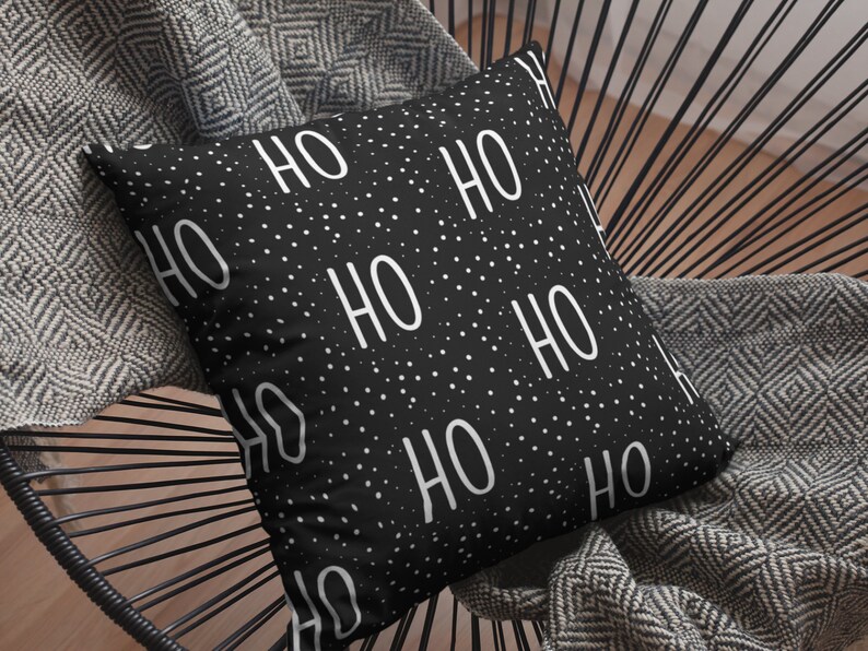 May include: Black and white throw pillow with a repeating pattern of "HO HO" text on a black background with white polka dots.
