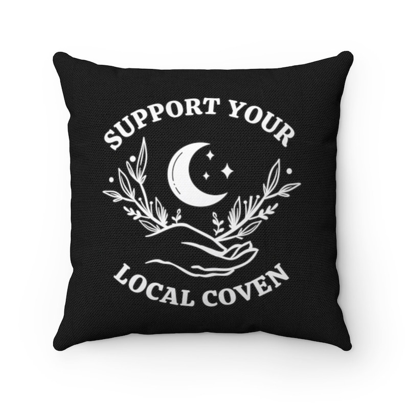 May include: Black throw pillow with white text that reads "Support Your Local Coven" and a crescent moon with stars above a hand holding a sprig of leaves.