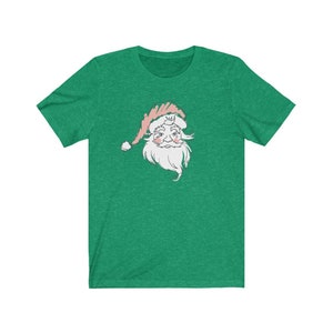 May include: A green t-shirt with a white and pink illustration of Santa Claus's face.