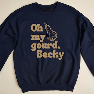 May include: A navy blue sweatshirt with a gold graphic that says "Oh my gourd, Becky" with a gourd illustration.