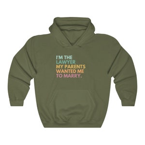 May include: A green hooded sweatshirt with the text "I'M THE LAWYER MY PARENTS WANTED ME TO MARRY." printed on the front in rainbow colors.