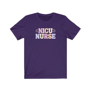 Peut inclure: T-shirt &agrave; manches courtes de couleur violette avec le texte "NICU NURSE" en lettres color&eacute;es.
