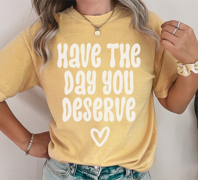 May include: A yellow t-shirt with the text "Have the day you deserve" in white with a heart at the bottom.