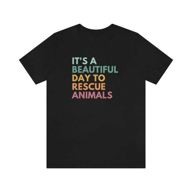 May include: Black t-shirt with the text "It's a beautiful day to rescue animals" in rainbow colors.