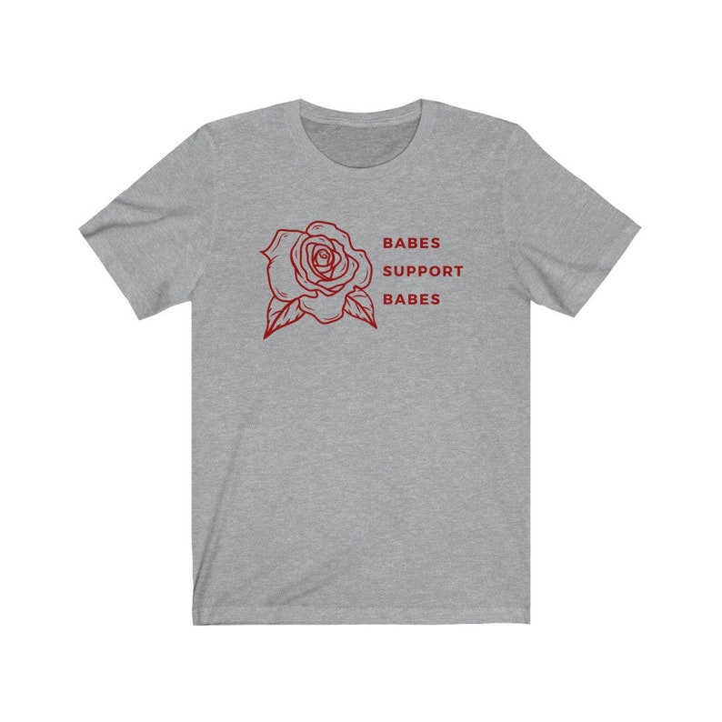May include: A heather gray t-shirt with a red rose graphic and the text "BABES SUPPORT BABES" printed on the front.