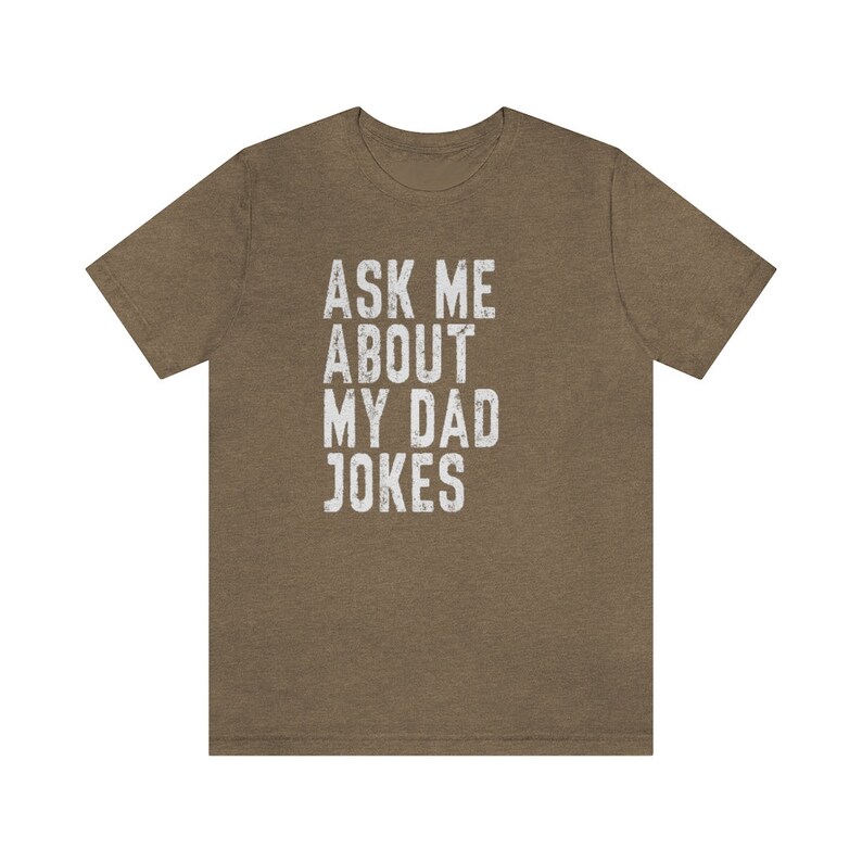 K&ouml;nnte beinhalten: Ein braunes T-Shirt mit dem Aufdruck "Ask me about my dad jokes" in wei&szlig;.