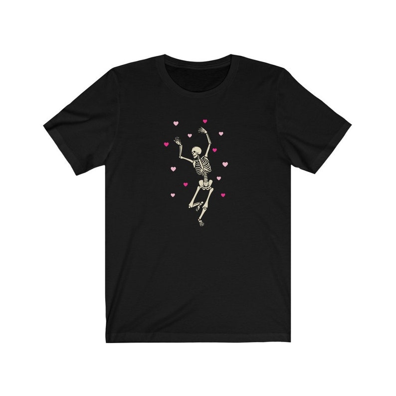 May include: Black t-shirt with a white skeleton dancing and surrounded by pink hearts.