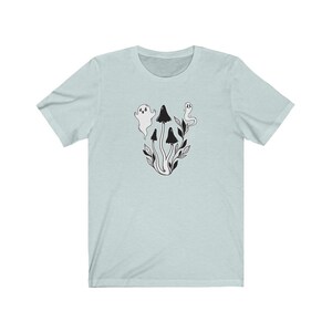 Puede incluir: Una camiseta azul claro con una ilustraci&oacute;n en blanco y negro de setas y fantasmas.