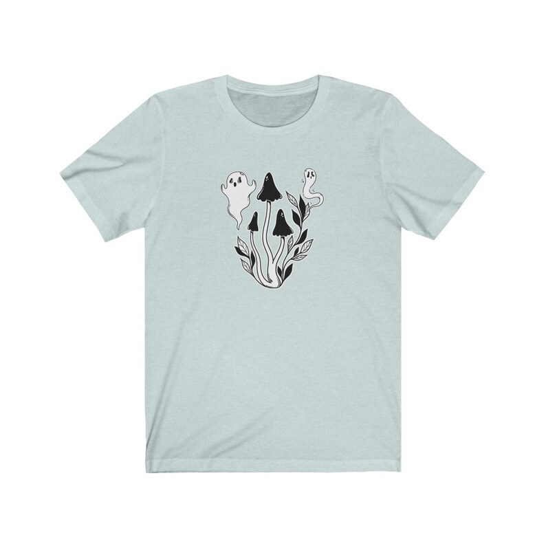 Puede incluir: Una camiseta azul claro con una ilustraci&oacute;n en blanco y negro de setas y fantasmas.