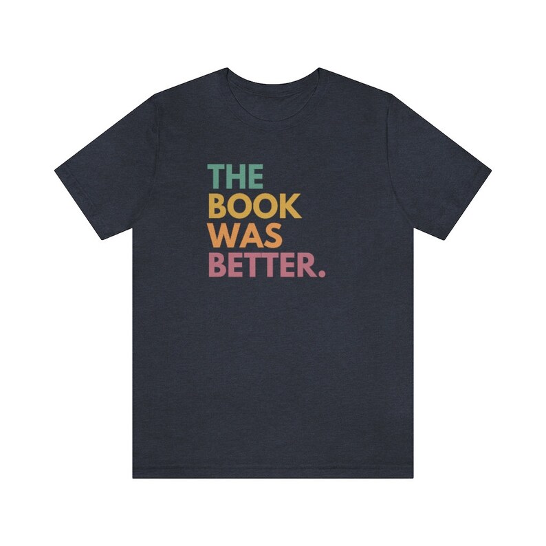May include: A dark blue t-shirt with the text "THE BOOK WAS BETTER." printed in rainbow colors.