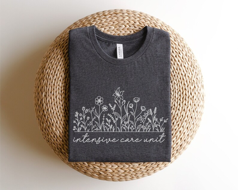 May include: A dark gray t-shirt with a white outline of flowers and the text "intensive care unit".
